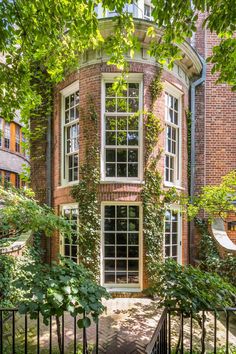 an old brick building with ivy growing on it's sides and windows in the front