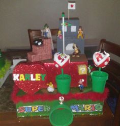 a table topped with cake and cupcakes covered in frosting next to other decorations