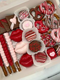 a box filled with lots of different types of heart shaped cookies and candies next to each other