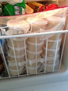 a refrigerator filled with lots of food and drinks in plastic bags on top of it