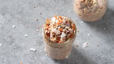 two jars filled with food sitting on top of a cement floor next to each other