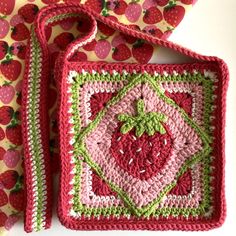 two crocheted strawberry coasters sitting next to each other