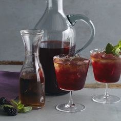 three glasses and pitchers filled with different types of drinks