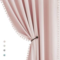 a pink curtain with pom poms hanging from it