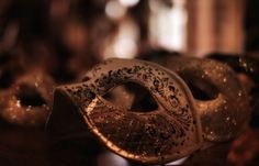 two masks sitting on top of a wooden table