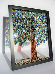 a tree made out of stained glass sitting in front of a white wall