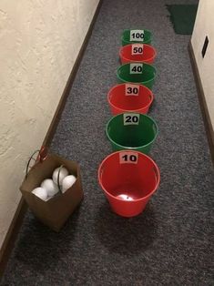 several buckets are lined up on the floor in front of numbered numbers and eggs