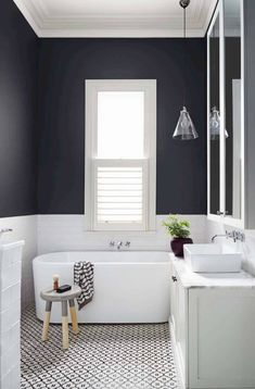 a white bath tub sitting under a window in a bathroom