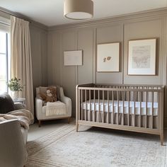 a baby's room with a crib, chair and pictures on the wall