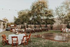 an outdoor party with tables and chairs set up in the yard for a wedding reception