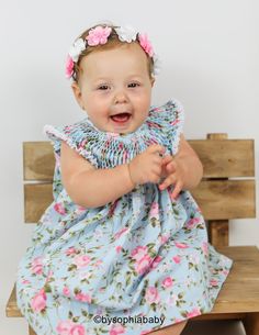 "**BLUE AND PINK FLORAL BABY DRESS (DRESS ONLY) --> MANY PRINTS AND COLORS AVAILABLE---> https://www.etsy.com/shop/BySophiaBaby?ref=seller-platform-mcnav&search_query=1130 { DRESS DESCRIPTION }: - Unique Baby Dress, made with 100% COTTON, with a beautiful handicraft detail called \"Bee House\" or \" Hive\" on upper part of the dress. - This listing is for the Dress only, if you want to purchase a matching headband please click on the links below: ---> Flower Crowns: https://www.etsy Fitted Blue Dress For First Birthday, Blue Fitted Dress For First Birthday, Playful Baptism Dress With Ruffles, Playful Pink Dress For Baptism, Playful Pink Baptism Dress, Blue Dress For First Birthday In Summer, Blue Sleeveless Dress For First Birthday, Ruffled Baby Bloomers, Baby Ruffle Romper