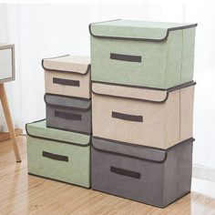 four storage bins stacked on top of each other in front of a wall with a mirror