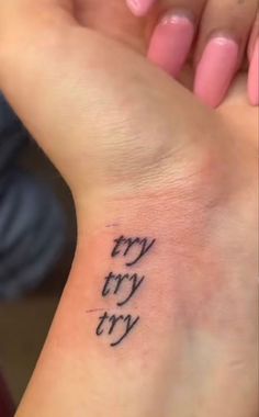 a woman's wrist tattoo with the words try try try