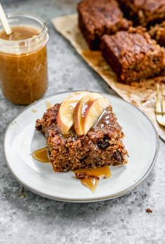 a piece of cake sitting on top of a white plate next to a jar of peanut butter