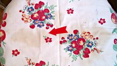 an up close view of a table cloth with flowers and arrows pointing to the center