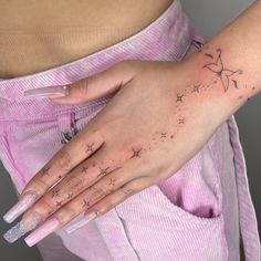 a woman's hand with stars on it and a star tattoo on her left wrist