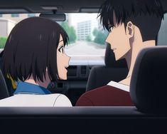 two people sitting in the back seat of a car looking at each other and smiling