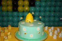 there is a cake that has been decorated with flowers and bees on it in front of balloons