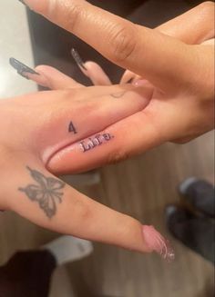 two people with tattoos on their fingers pointing at each other's fingernails