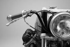 a close up of a motorcycle headlight on a gray background with an orange light