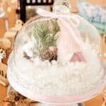 there is a snow globe with a baby in it on the table next to other decorations