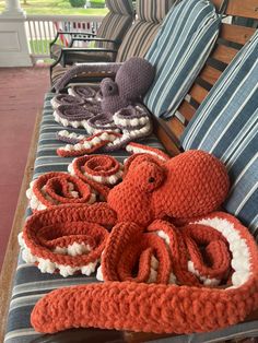 an octopus is laying on the back of a couch with two crocheted pillows