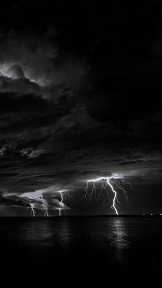 black and white photograph of lightning over the ocean