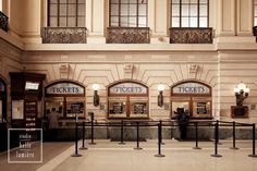 an empty train station with people waiting for their trains to arrive at the ticket booth