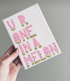 a person holding up a card with the words you're one in a melon on it