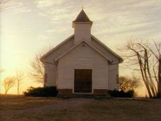 an old church sits in the middle of a field