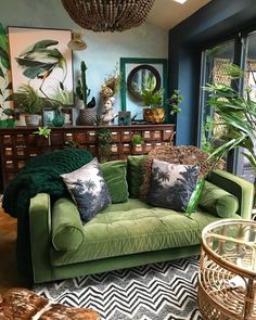 a living room filled with green furniture and lots of plants on top of the couch