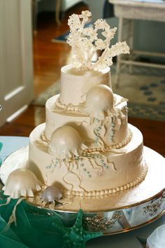 a three tiered wedding cake with white frosting and elephants on the top layer