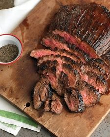 the steak is sliced and ready to be served on the cutting board with seasoning