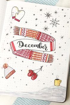 an open notebook with the words december written on it, and some decorations around it