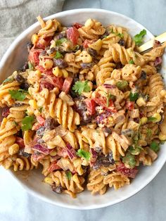 a white bowl filled with pasta salad on top of a table