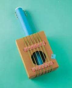 a cardboard box with a blue toothbrush inside on a green surface, top view