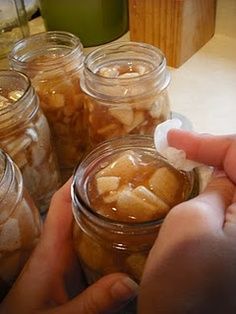 a person is picking up some food from a jar