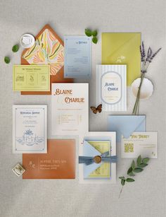 the wedding stationery is laid out on top of each other, including cards and envelopes