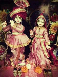 two figurines are dressed in pink and gold