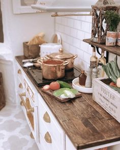 a kitchen counter with pots and pans on it, including an old fashioned stove