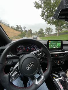 the inside of a car with steering wheel, dashboard and display screen showing information about cars