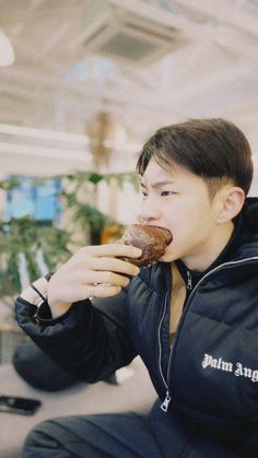 a young man eating a donut while sitting down