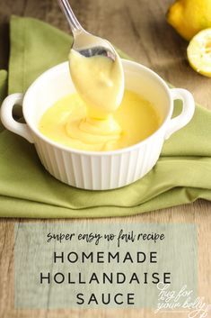 a spoon full of homemade hollandaise sauce in a white bowl on a green napkin