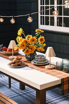 Celebrate the shift of seasons by refreshing your outdoor space with autumn-inspired decor. Start with a plaid runner and a matching plaid area rug for a cozy base. Add warmth with neutral portable table lamps and timeless string lights. Finish with fluted glasses and a simple vase for sunflowers – both in classic shades of tinted blue.

Shop for your home at Birch Lane. Outdoor Table Centerpieces, Outdoor Fall Decor, Plaid Table Runner, Plaid Area Rug, Simple Vase, Autumn Inspired, Fall Outdoor Decor, Portable Table