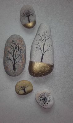 three rocks with trees painted on them