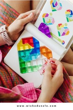 a woman is holding a colorful puzzle in her hands