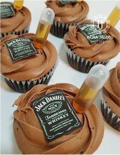 chocolate cupcakes with frosting and a bottle of jack daniels whiskey on top