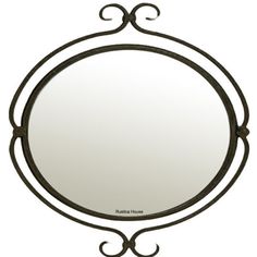 a round mirror sitting on top of a white wall next to a black metal frame