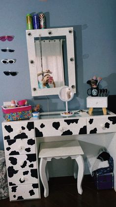 a cow print desk and chair in front of a mirror with sunglasses on the wall