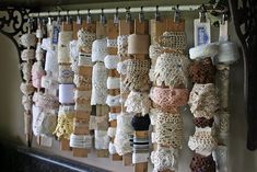 the wall is covered with many different types of laces and crocheted items